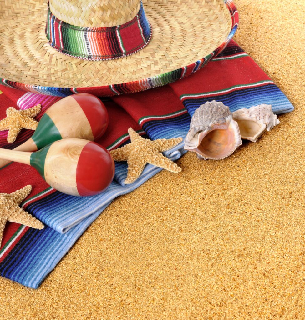 Sombrero mexicano y maracas en la playa para ambientar la fiesta del grito de la independencia de México.