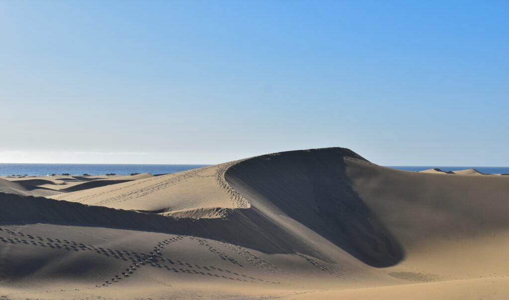 foto-fascinante-de-dunas-de-arena-contra-el-azul-de-la-playa